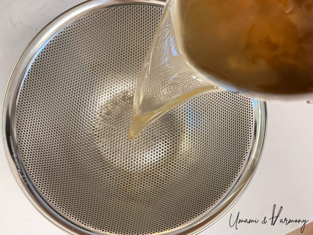 Bonito flakes being strained from homemade dashi