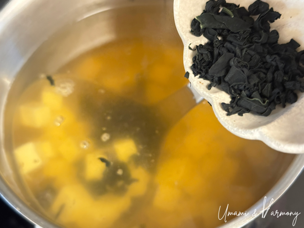 Dried wakame being added to homemade dashi