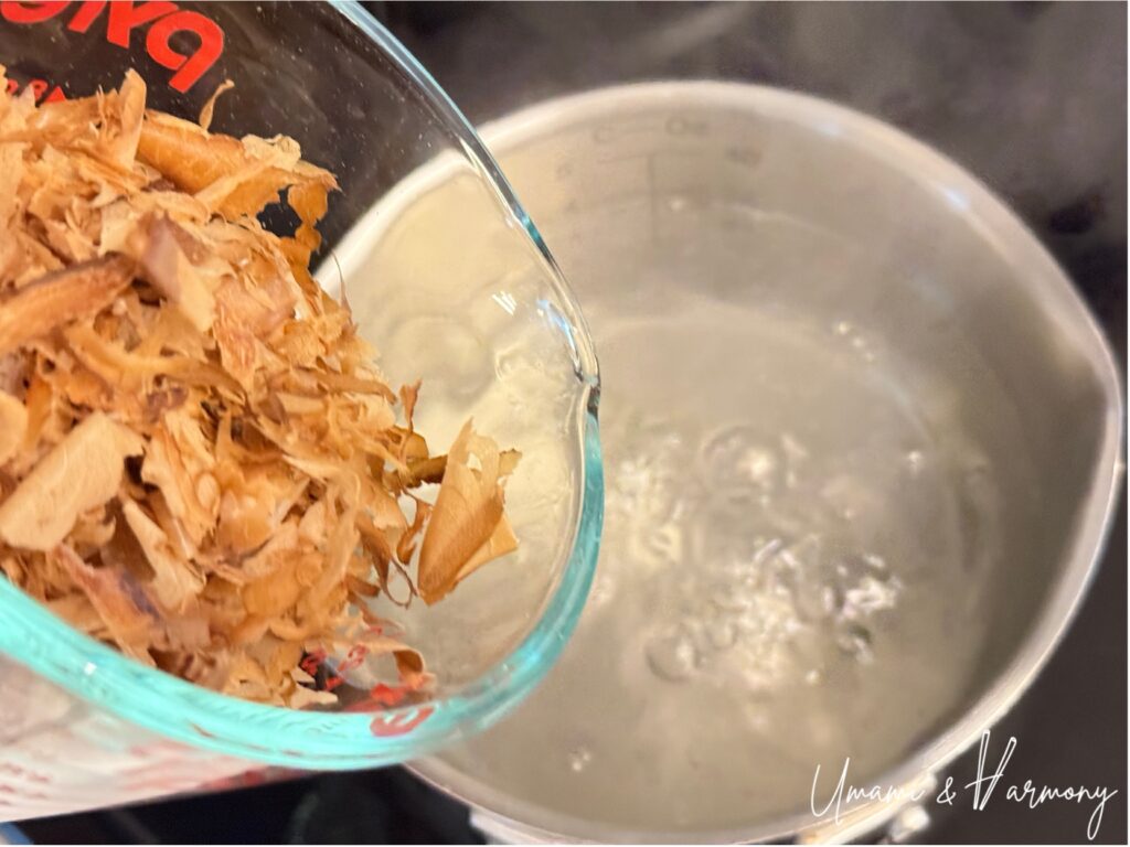 Bonito flakes being added to hot kombu dashi