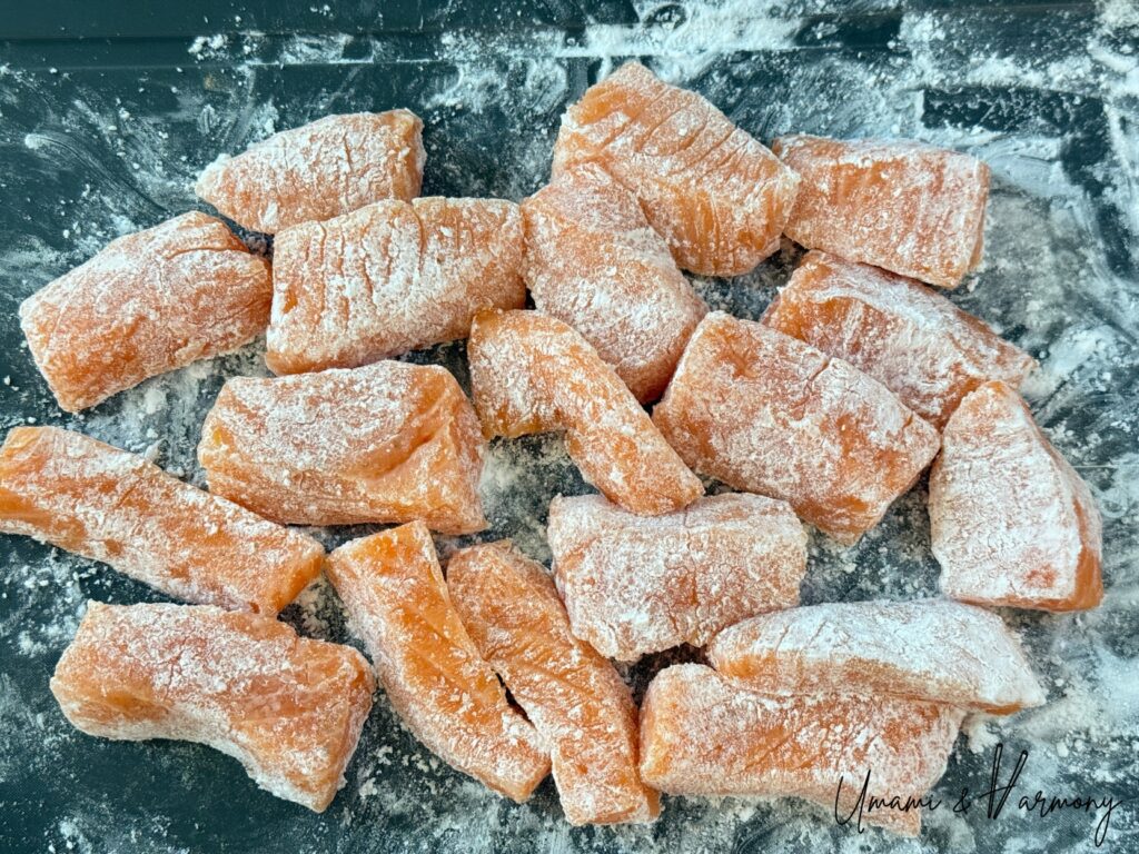 Salmon evenly coated with potato starch before pan-frying