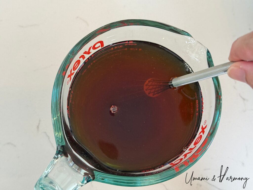 Dashi, rice vinegar, soy sauce, sugar, and mirin mixed in a cup
